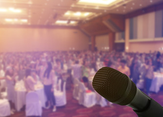 Microphone over the Abstract blurred photo of banquet room or seminar room with people background,party or meeting concept.