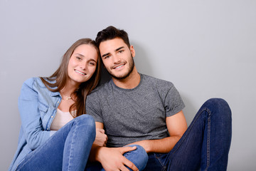 happy young lovely couple sitting on the floor of new home flat apartment with empty space