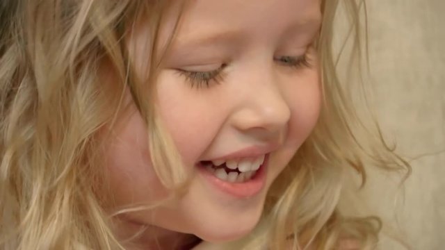 Closeup of cute blonde little girl laughing at something