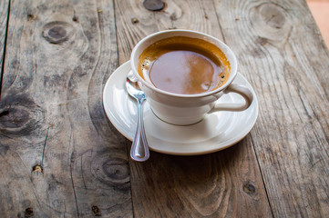 Hot Americano coffee in white cup on wooden table. This is how the makers of hot water mixed into the espresso. Americano is for those who prefer black coffee.
