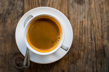 Hot Americano coffee in white cup on wooden table.