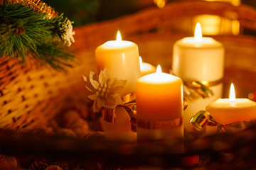 Christmas decorated with ribbons candle stand in cart with nuts near the Christmas tree. Filmed closeup.