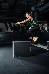 Fototapeta na wymiar Young woman doing a box jump exercise.