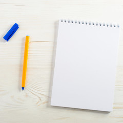 school empty notebook and pen, frame for your text, light wooden background, top view. Concept of back to school or education