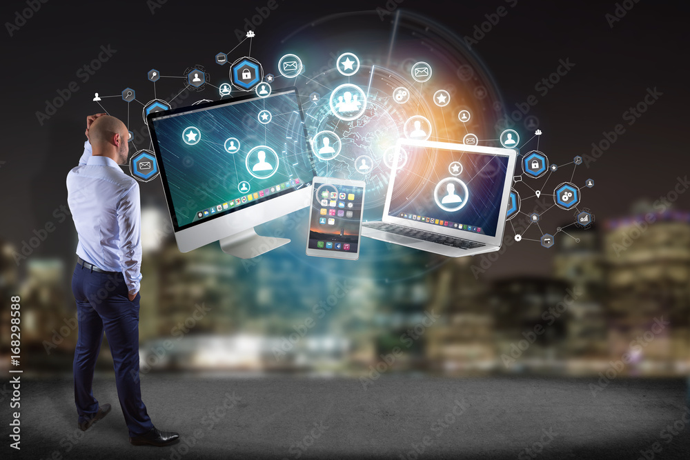 Poster businessman in front of a wall with computer and devices displayed on a futuristic interface with bu