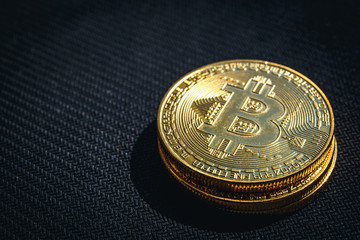 Stack of golden Bitcoin coins on black