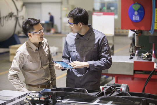 Confident engineers talking in the factory
