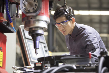 Confident engineer working in the factory