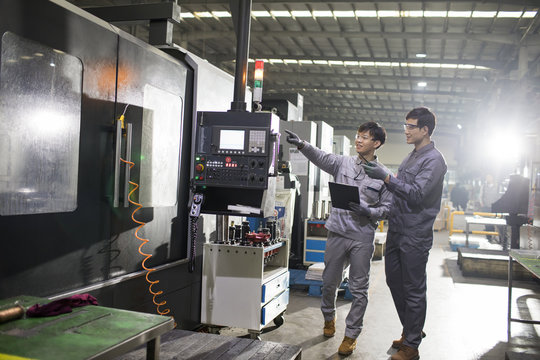 Confident engineers working in the factory