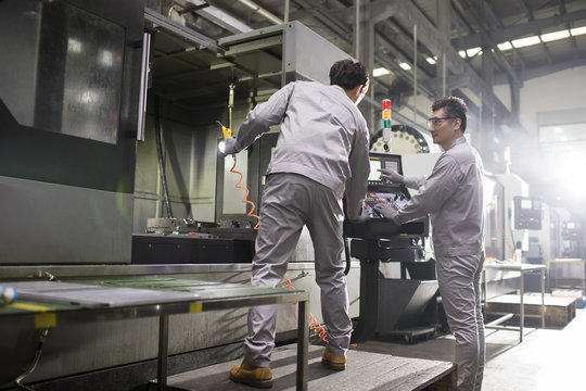 Confident engineers working in the factory