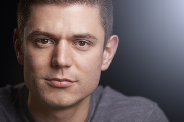 Close up portrait of a young white man looking to camera