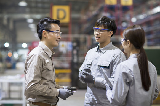 Confident engineers talking in the factory