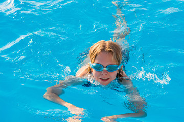 Girl swims in the pool with glasses for swimming