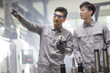 Confident engineers working in the factory