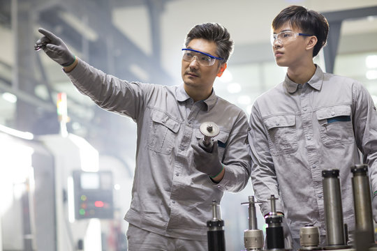 Confident engineers working in the factory