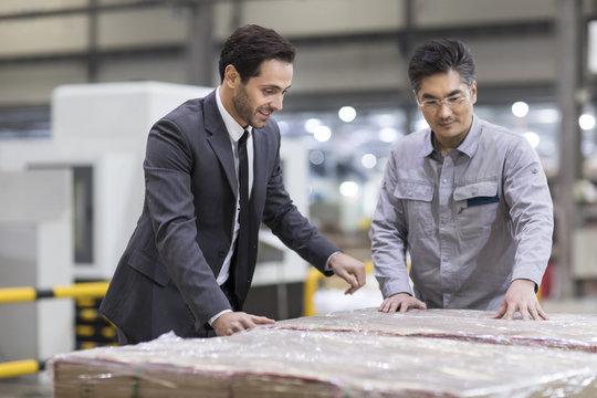 Businessman and engineer talking in the factory