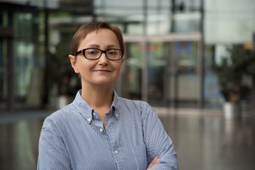 Nice portrait of middle aged business woman in the office. Headshot of older female person wearing glasses. Teacher, principal, interview. - 168302703