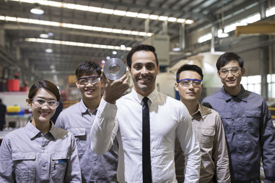 Confident businessman and engineering team in the factory