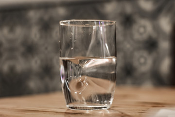 Modern glass of water sitting on a table with blured background