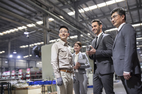 Business people and engineer in the factory