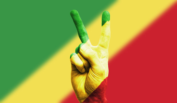 Republic of Congo national flag painted onto a male hand showing a victory, peace, strength sign