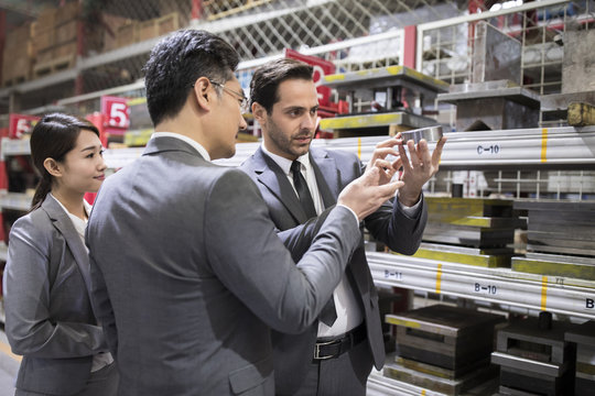 Business people checking machine parts in the factory