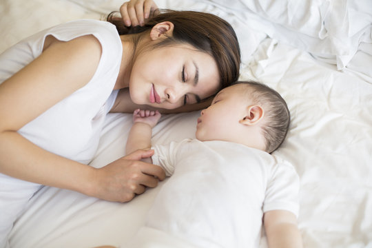 Young mother and son sleeping in bed