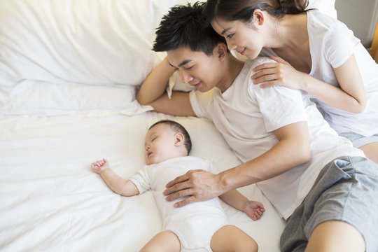 Young parents with sleeping baby boy