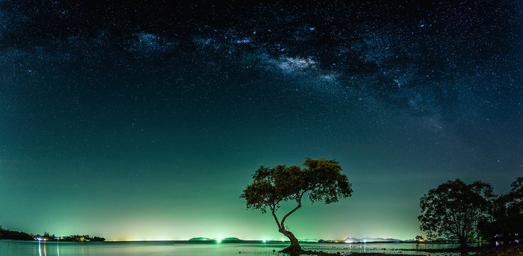 Fototapeta Landscape with Milky way galaxy. Night sky with stars and silhouette mangrove tree in sea. Long exposure photograph.