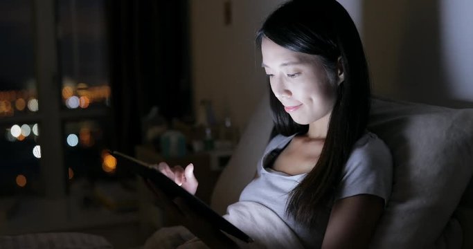 Woman use of tablet computer on bed