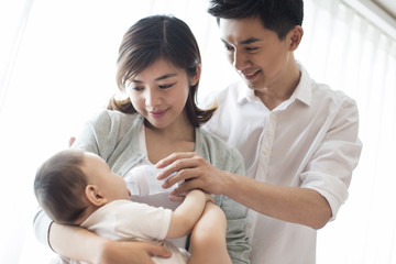 Young parents feeding baby