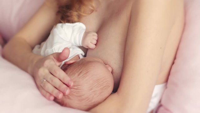 Young mom holding a baby and breastfeeding. Breast feeding a baby