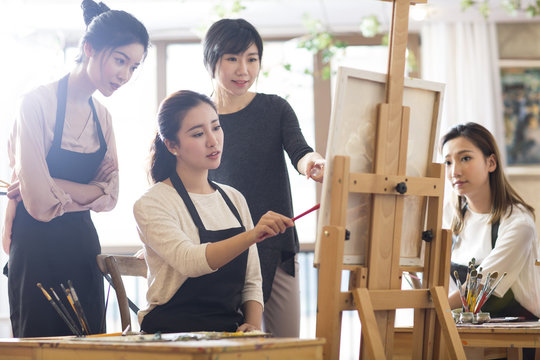 Art teacher with young women in studio
