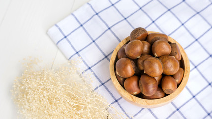 Chestnuts in a bowl on a wooden table.