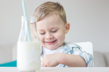 A cute little boy is eating candy and drinking milk. Health. Happy child. Breakfast. A little boy is sitting at the table.