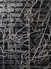 Abstract art of silver aluminum cloth hangers attaching altogether, hanging on black brick wall background