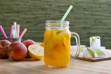 cocktail o succo di frutta con pesche in barattolo di vetro sfondo tavolo di cucina