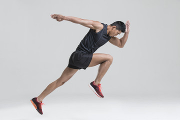 Male athlete running against white background