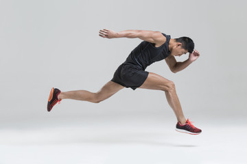 Male athlete running against white background