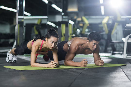 Young couple exercising at gym