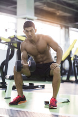 Fototapeta na wymiar Young man exercising at gym