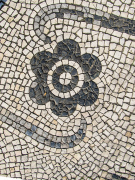 Traditional portuguese pavement (calcada portuguesa) with a flower detail in Faro, Portugal