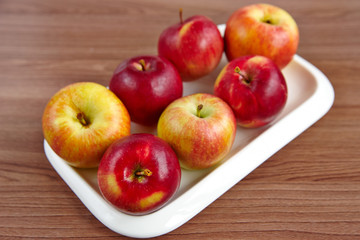 A plate with apples on a wooden table