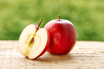 A whole apple and half an apple on a rustic wooden table