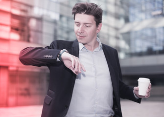 Businessman hurrying to meeting and watching on wristwatch