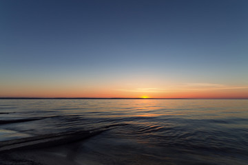 Fototapeta na wymiar sunrise on the water Early summer morning bright sky Beach