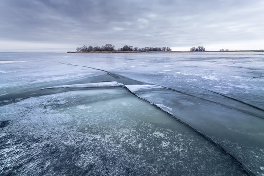 winter frozen lake / the rift of ice stretching into the horizon twilight