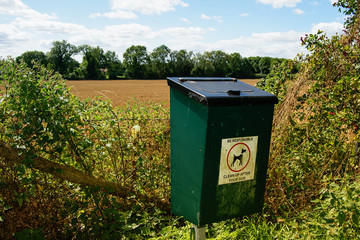 Dog waste bin. Countryside landscape.