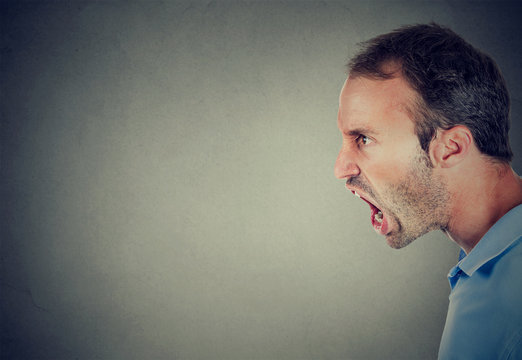 Side profile of an angry young man screaming