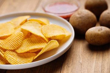 Potato chips on white dish, potato and sauce 
